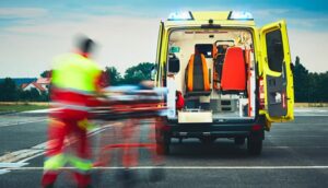 operatore che porta un paziente su barella dentro a un'ambulanza 